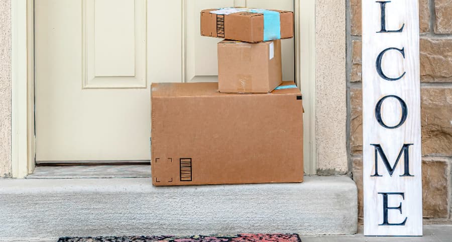 Packages on the doorstep of a home with a welcome sign in Portland